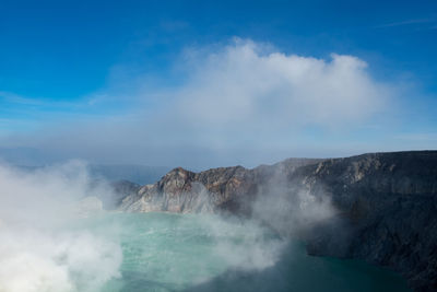 View of volcanic mountain against cloudy sky