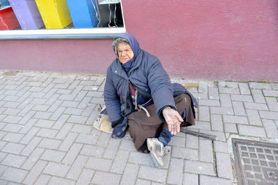 Full length portrait of man sitting outdoors