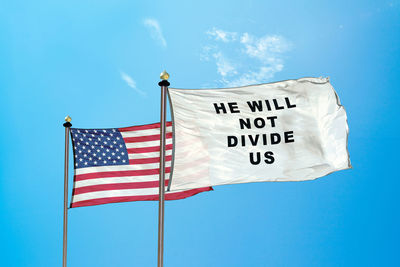 Low angle view of flags against blue sky