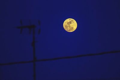 Low angle view of moon against blue sky