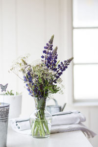 Close-up of flowers vase on table at home