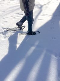 Low section of man walking on snow