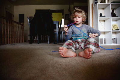 Portrait of cute boy sitting on floor