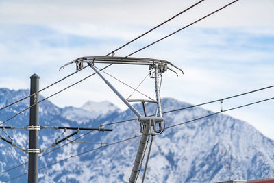 Low angle view of electricity pylon against sky