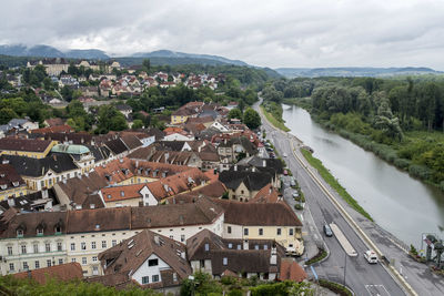 Aerial view of river by cityscape against sky