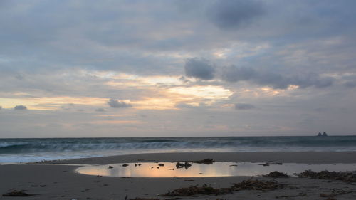 Scenic view of beach against sky during sunset