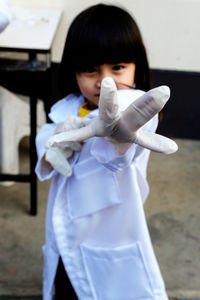 Portrait of girl wearing lab coat and gloves