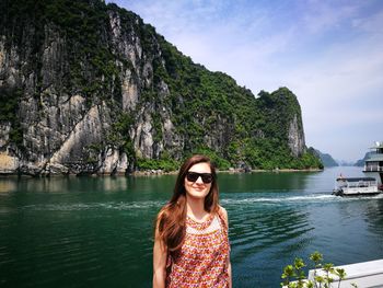 Portrait of beautiful young woman standing at lakeshore