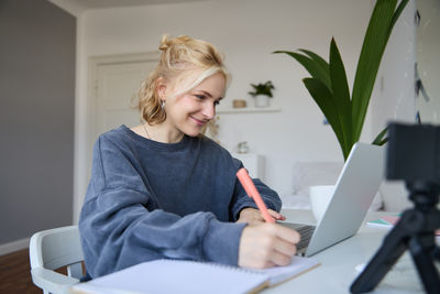Portrait of woman using digital tablet while sitting at home