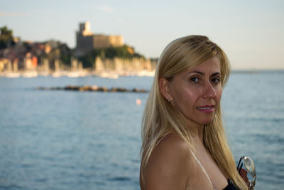 Portrait of young woman against sea