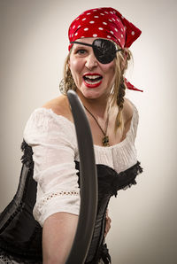 Woman in costume fighting with sword against white background