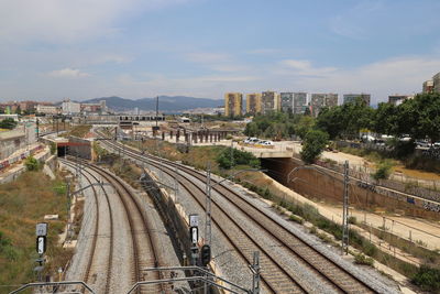High angle view of train and tracks in city against sky