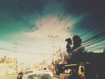 Electricity pylon against cloudy sky