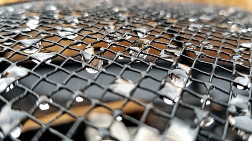 Full frame shot of wet chainlink fence during rainy season