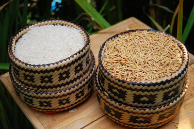 High angle view of wheat and rick in baskets on table