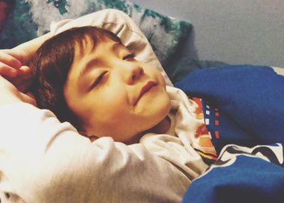 Portrait of boy sleeping on bed