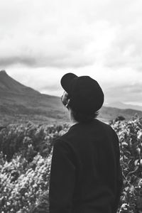 Rear view of man looking at mountain against sky