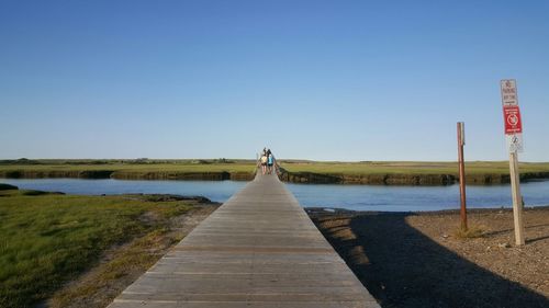 Scenic view of lake against clear blue sky