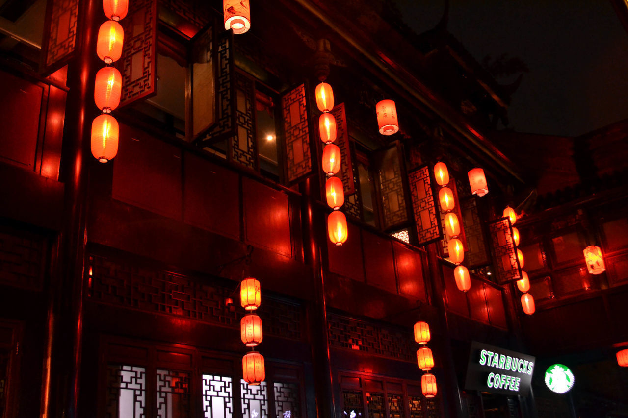 LOW ANGLE VIEW OF ILLUMINATED LIGHTS HANGING IN BUILDING