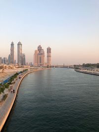 View of buildings by city against clear sky