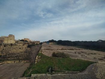 Road by landscape against sky