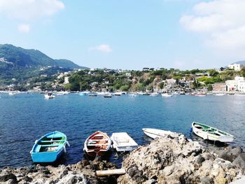 Boats moored in sea against sky