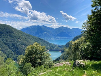 Scenic view of river by mountains against sky