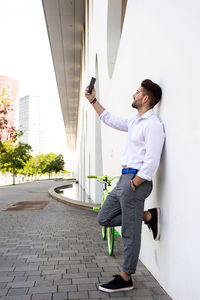 Portrait of stylish handsome young young man taking selfies with phone