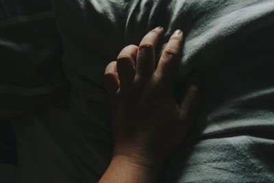 Close-up of hand on bed