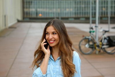 Smiling young woman talking on mobile phone