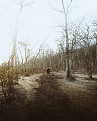 Rear view of man walking on dirt road