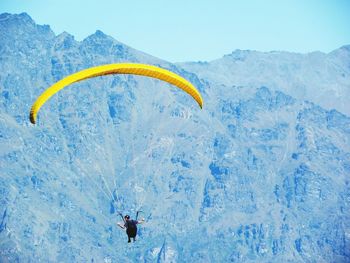 Person paragliding over mountain