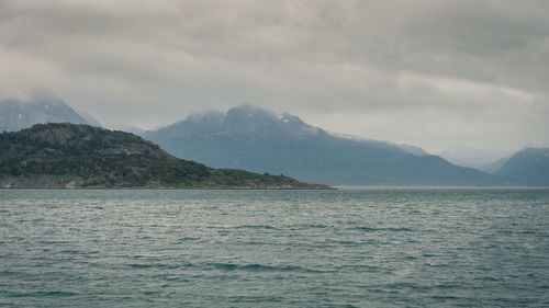 Scenic view of sea and mountains against cloudy sky