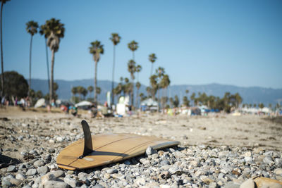 Close-up of surfboard at beach against clear sky