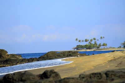 Scenic view of beach against blue sky