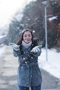 Portrait of young woman standing on snow