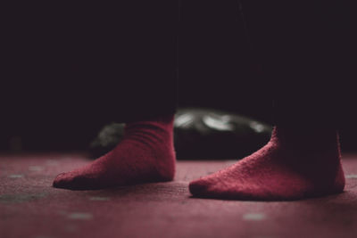 Low section of person wearing red socks standing at home