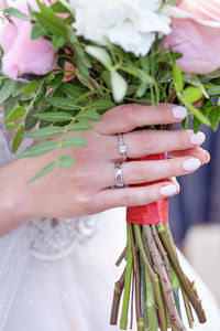 Bride's hand with a bouquet and a ring on the ring finger, close-up. beautiful wedding details