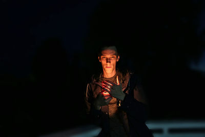 Night portrait of a man with a burning light in his hands