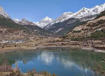 Scenic view of lake and snowcapped mountains against sky