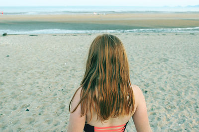 Rear view of woman standing on beach