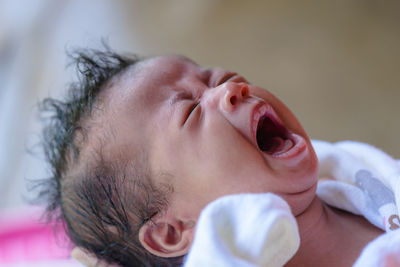 Close-up of baby girl crying at home