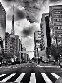 View of city street against cloudy sky