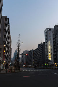 City street and buildings against clear sky