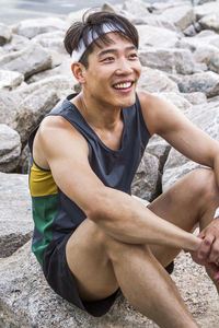 Male runner rests on rock after training run in brooklyn