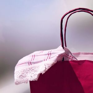 Close-up view of pink shopping bag against gray background