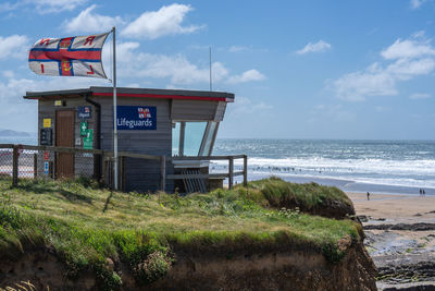 Lifeguard hut on beach against sky