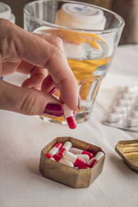 Close-up of hand holding drink on table