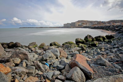 Rocks by sea against sky