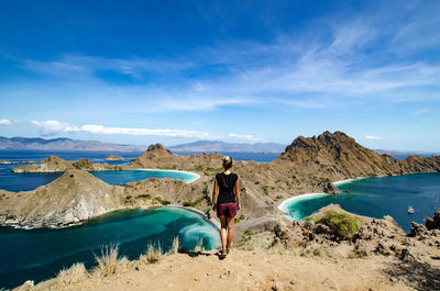 Rear view of woman on shore against sky